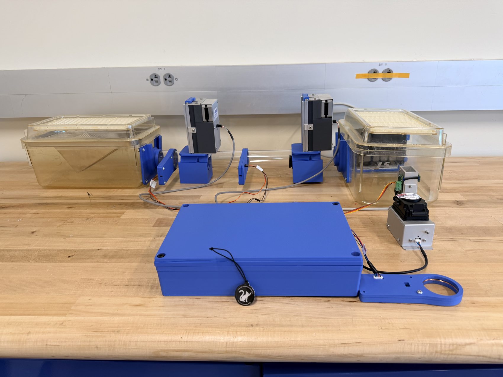 The full automated mouse cognitive-training rig: two chambers, touchscreen modules, and the control box